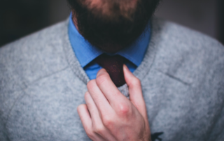 Close up of a man straightens his tie as he prepares for an interview discussing software developer career path