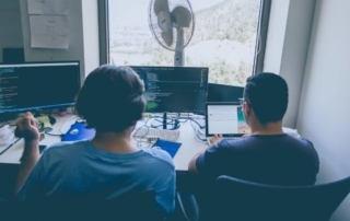 Two male data scientists using programming languages to code.