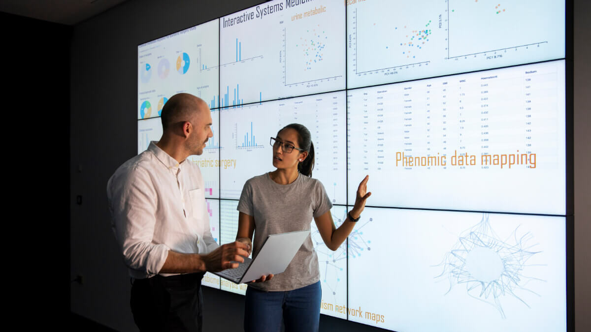Employees in front of data dashboard