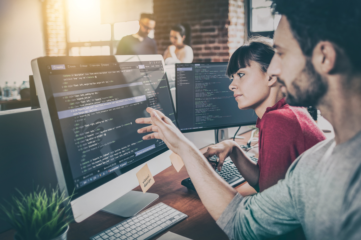 Two employees programming for a tech company after the company met the tech talent demand.