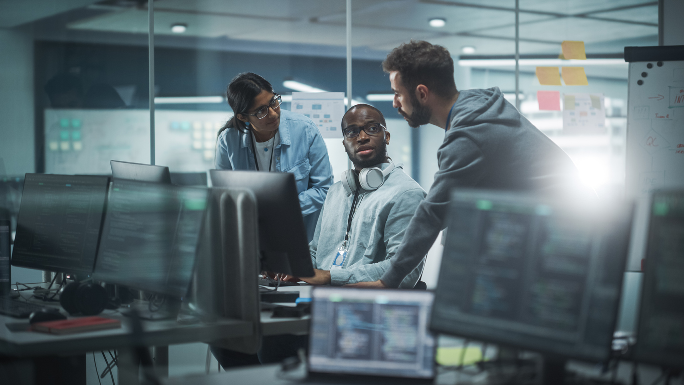 A group of professionals working cyber security jobs in a modern office.